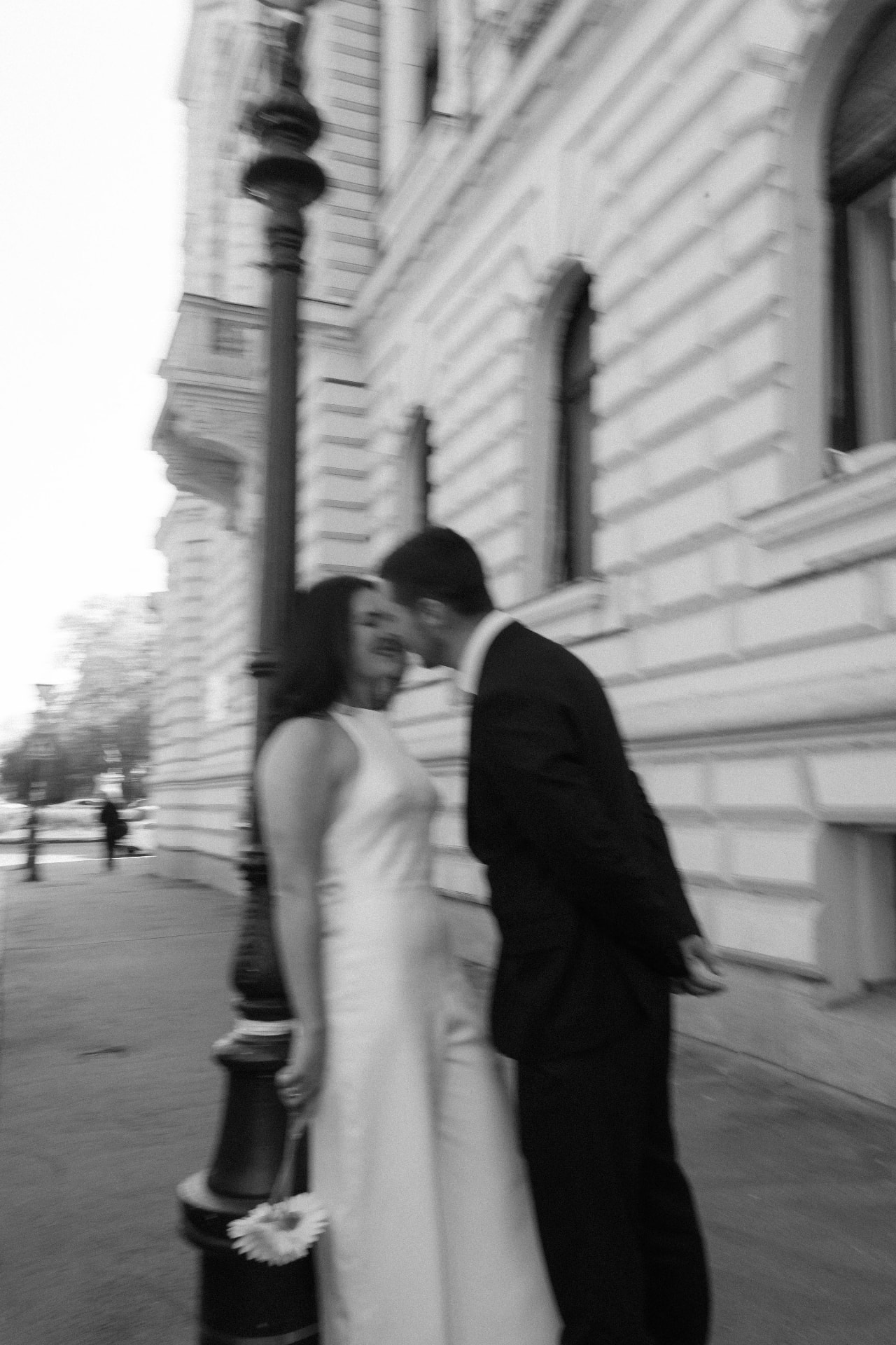 Couple against a building wall, black and white, intimate moment