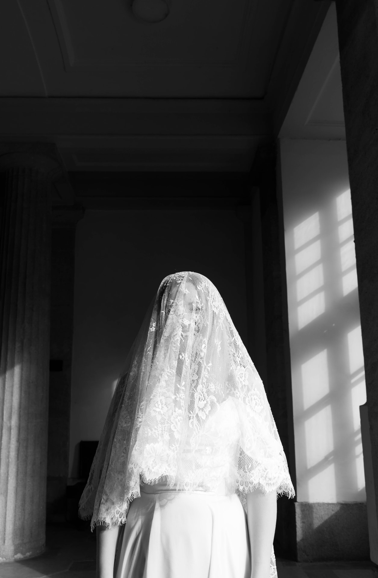 Bride in a lace veil, black and white, window light and shadows